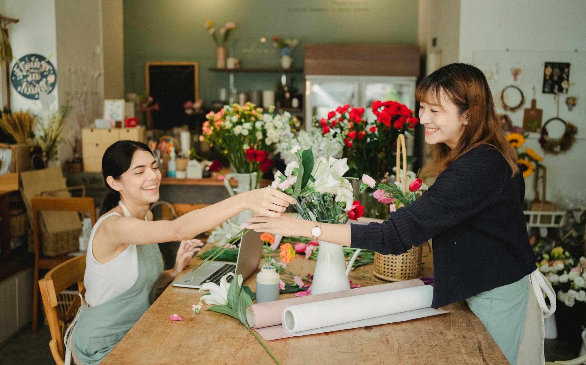 multiethnic coworkers in floral shop with laptop