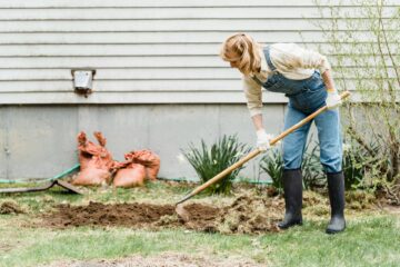 woman wearing denim overalls and wellies gardening